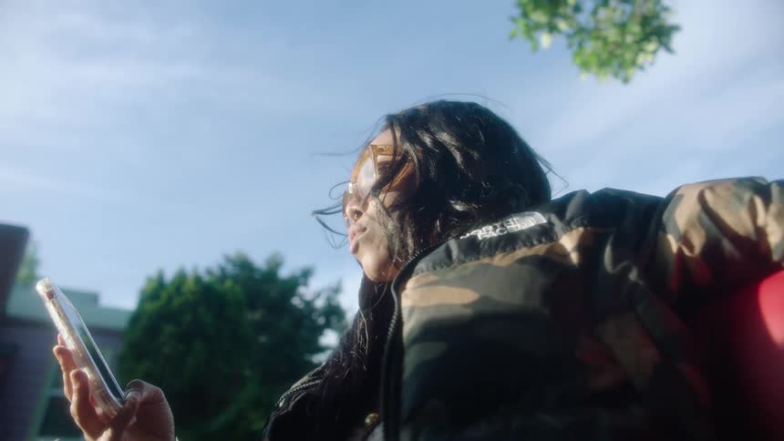 A woman is looking at her cell phone as she rides a vehicle