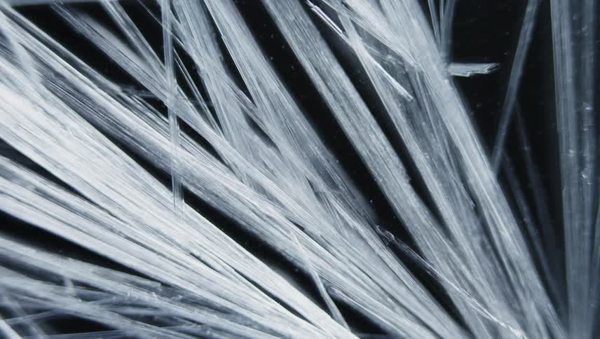 White lines grow and spread like cracks across the darkness