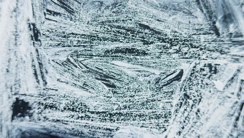 Ice crystals form on dark glass turning surface white with frost