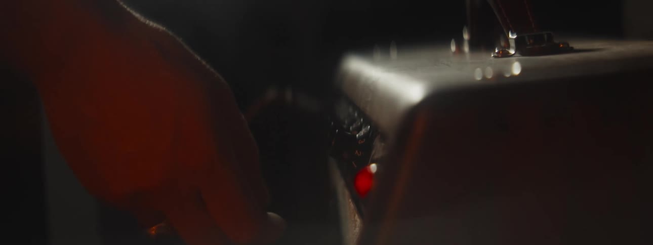Close up of the hand of a musician turning the knobs on a vintage amplyfier