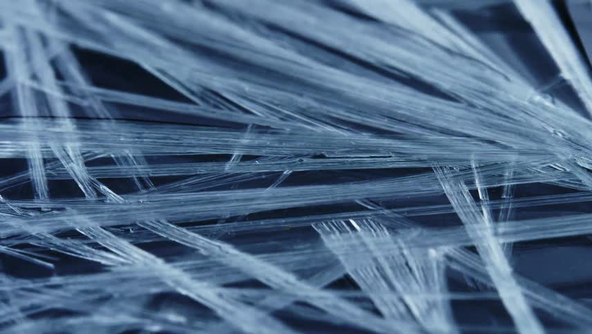 Ice crystals are being formed in water and are shown slowly evolving and highly magnified