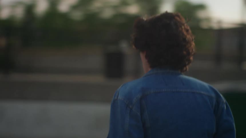 Person walks quickly running a hand through their hair