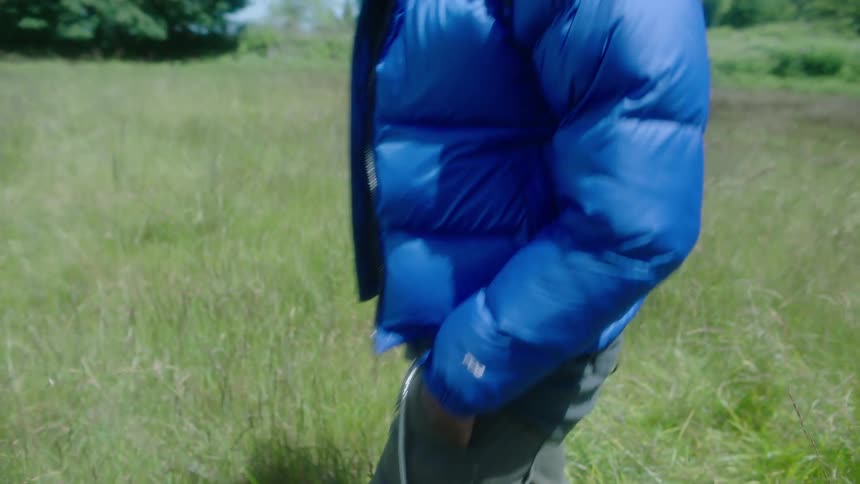 A man leisurely walks through a field during the day