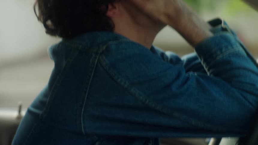 Young man angrily pounds the steering wheel of his car and grabs his hairs in desperation