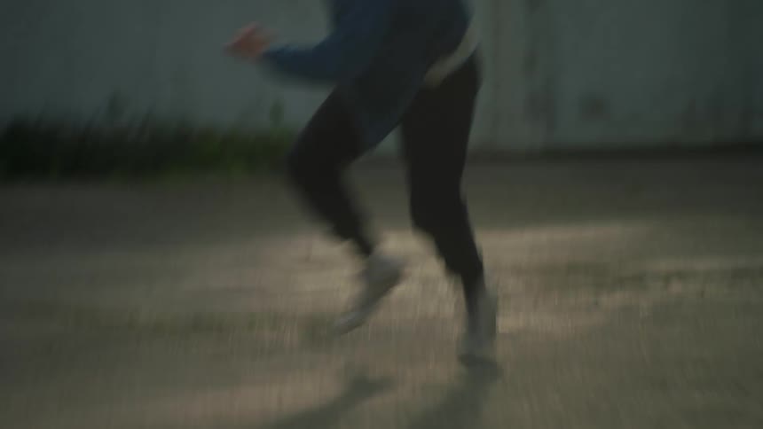 A teenager tumbles on the ground while running and screaming