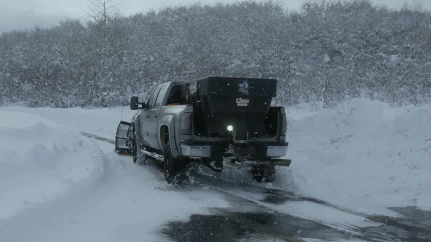 A truck with a plow clearing a road