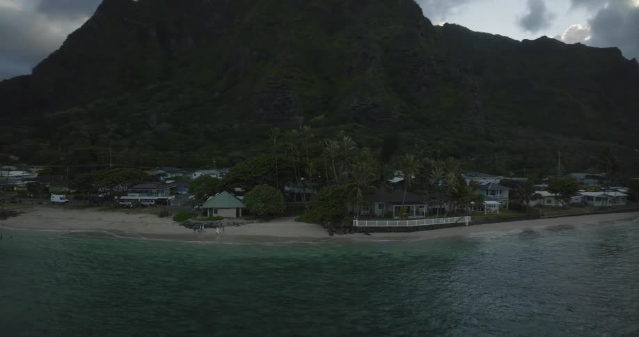 A neighborhood sits on the beach below a promontory