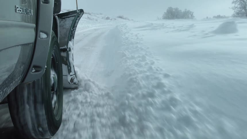 A plow on a truck removes snow