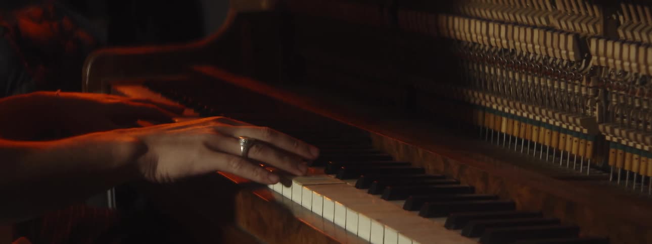 Close up of womans hands playing grand piano with the mechanism and strings in upright pianos