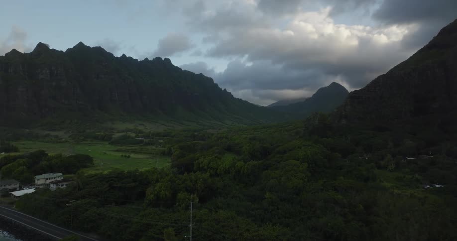 A verdant mountain valley on the coast under a cloudy daytime sky
