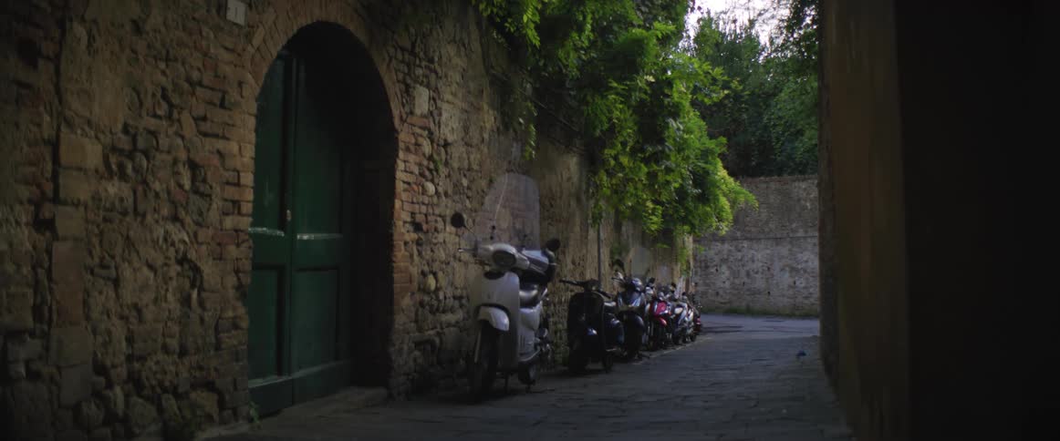 Scooters sit parked outside a building in a quaint town