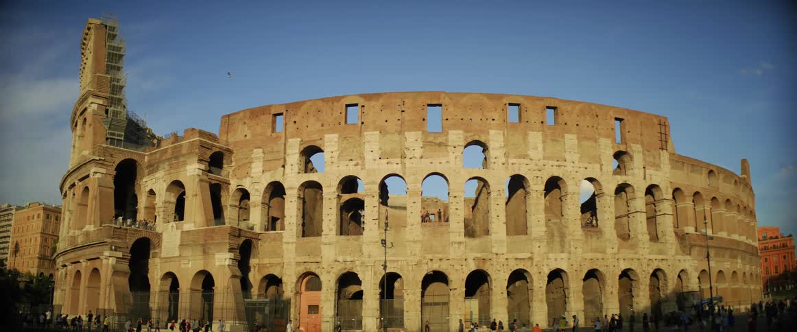 A large crowd waits to go inside a historical colloseum