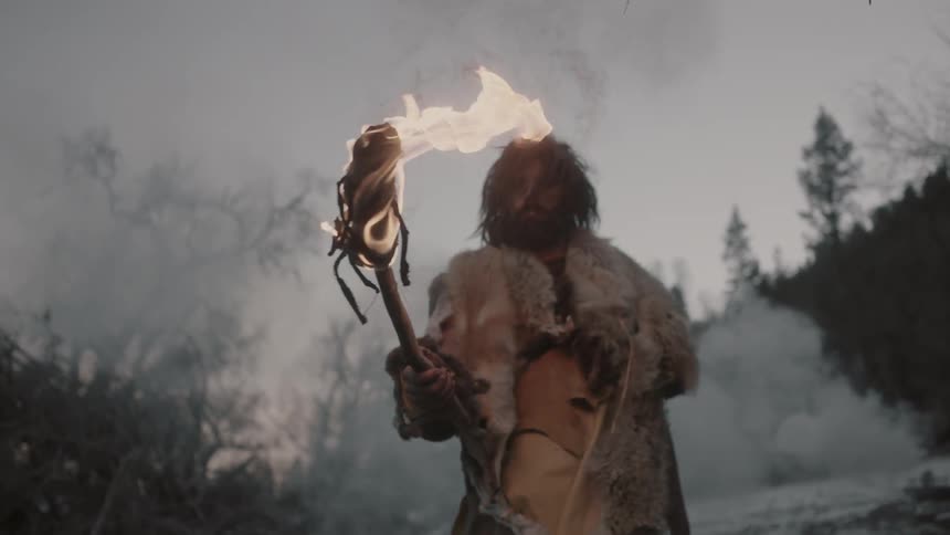 A man is carrying a torch outside on a cloudy day