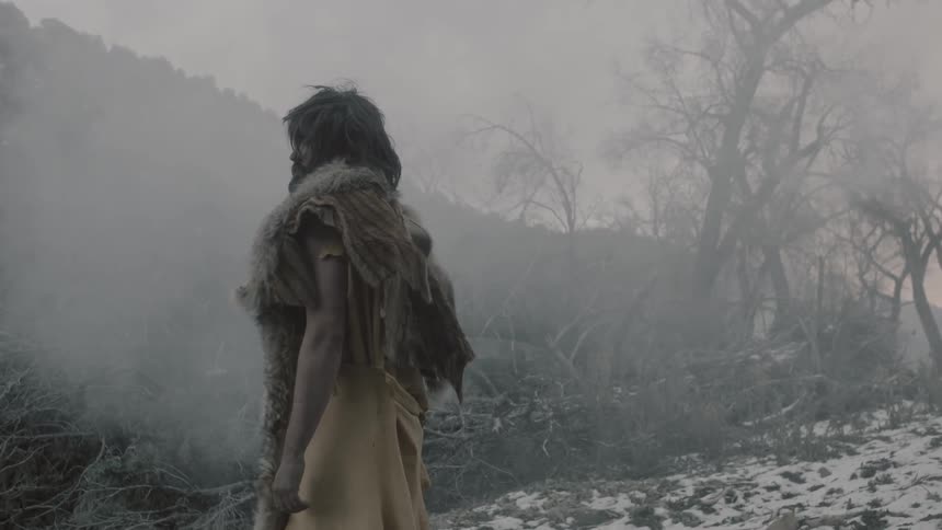 A man gazing off into the distance as smoke rises nearby