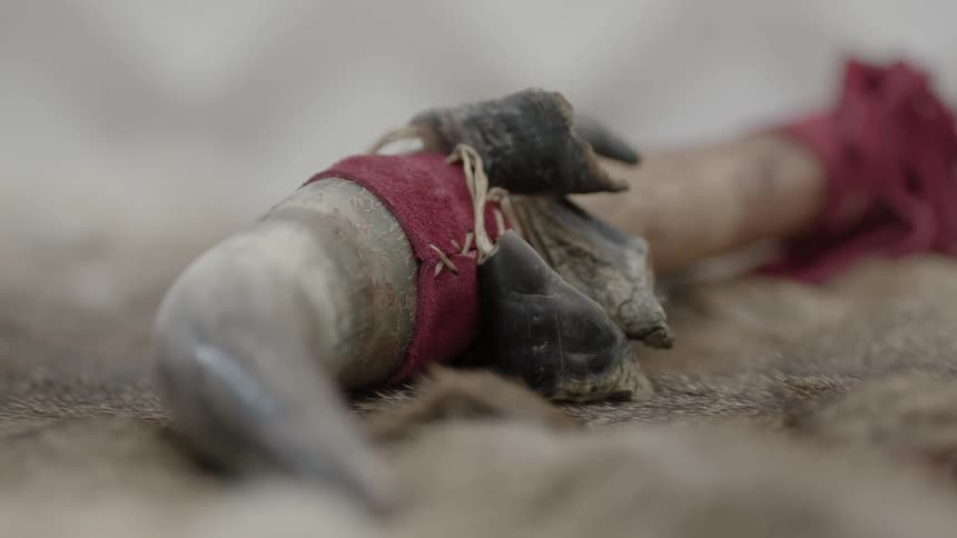 A decorated sharp tool is lying on a piece of fur