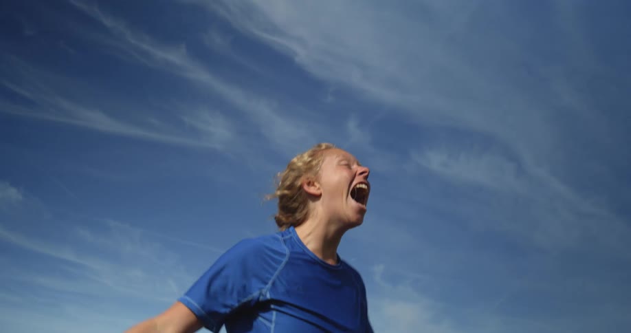 Female athlete jumps in celebration before running