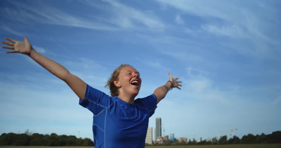A young woman jumps in celebration in a park