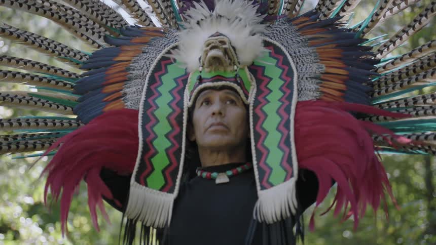 A man donning a large, feathered headdress