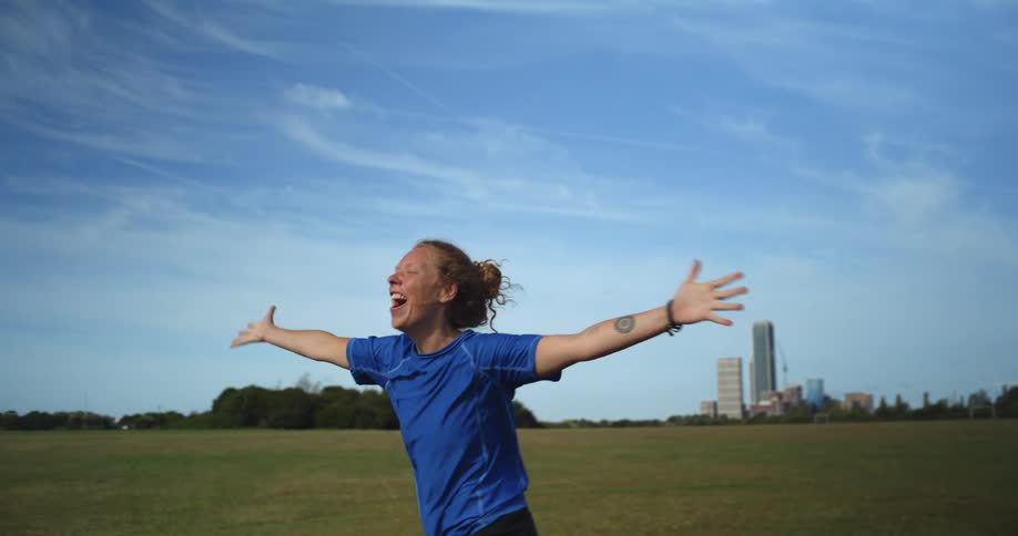 A woman celebrates on a soccer pitch