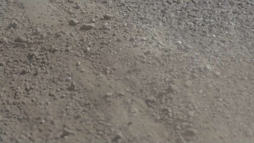 A bike tire traveling over dirt and gravel