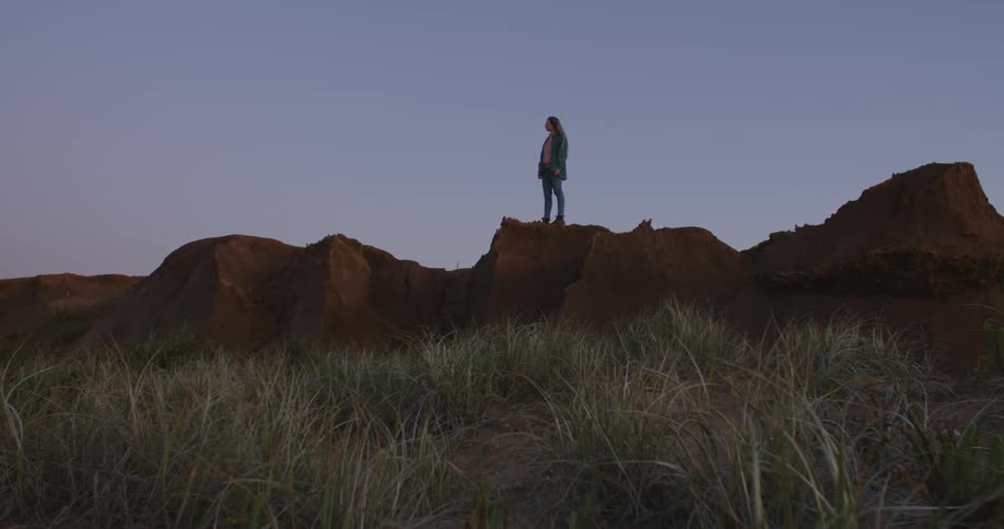 A person standing on a rock formation at dusk
