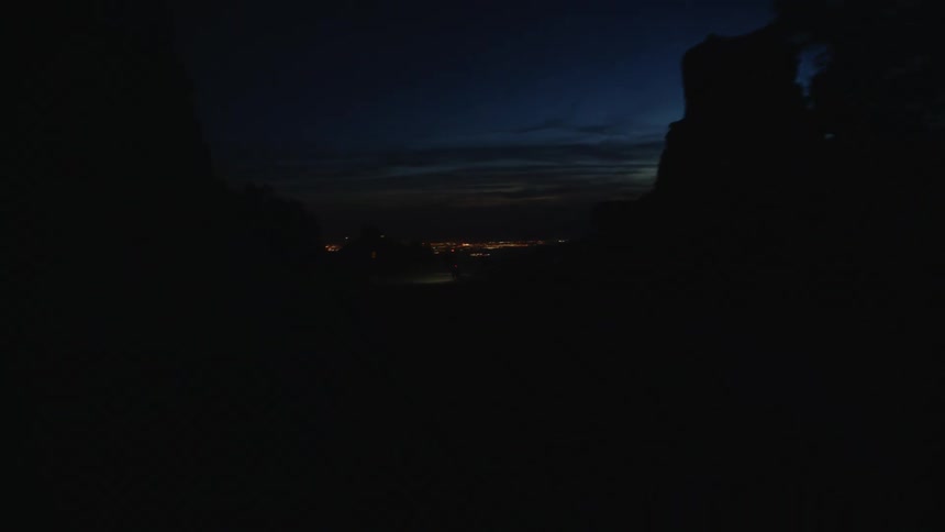 Red flashing light on the back of a bicycle on a road through the desert at night