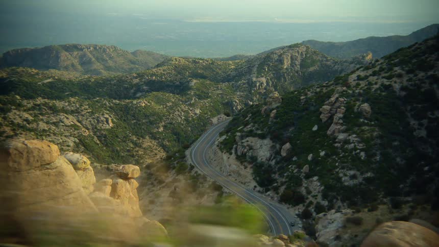 An empty curving highway on a mountain near rock formations