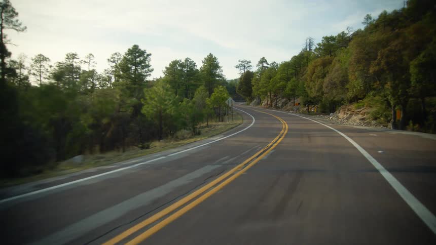 A vehicle travels on the curved highway