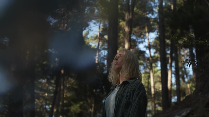A woman is standing in the forest