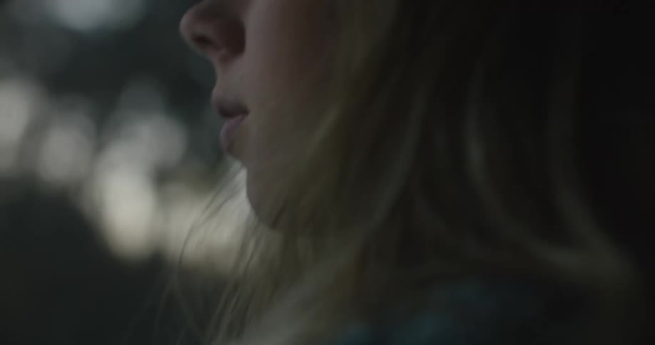 Sunlight shines on the face of a teenage girl as she rides in an automobile
