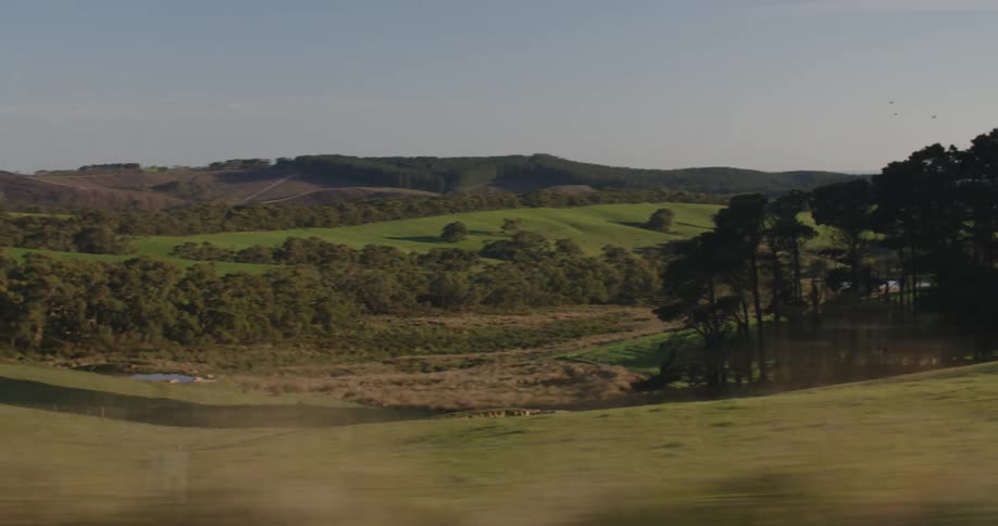Looking at the gentle hills on the rural countryside seen from a moving vehicle