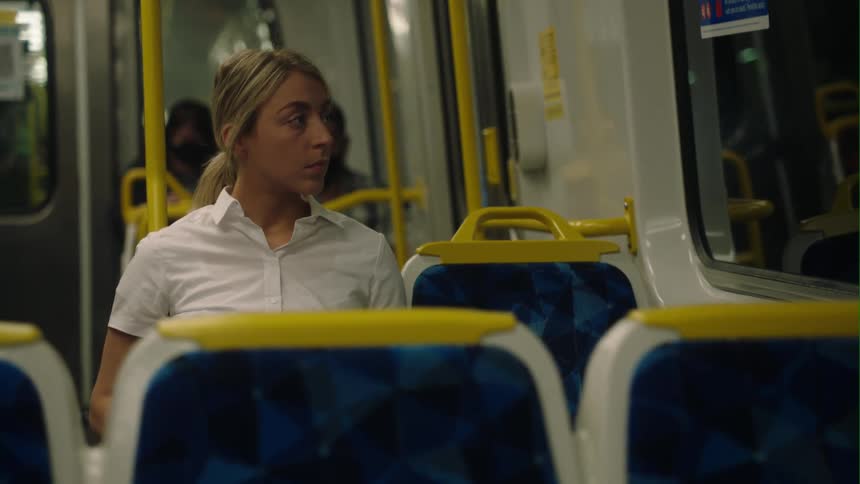 A woman sitting on a train looking out the window