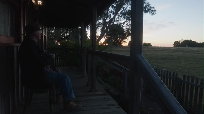 A man sitting on a patio at dusk