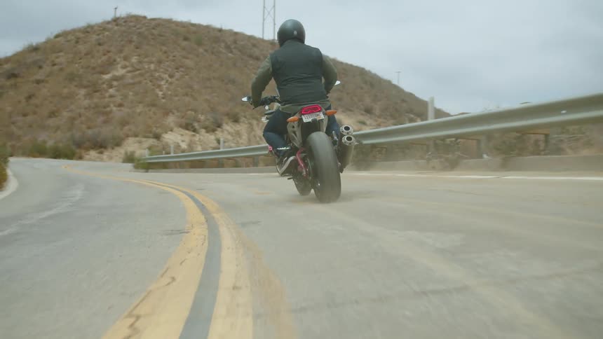 Two people drive on the highway on motorcycles