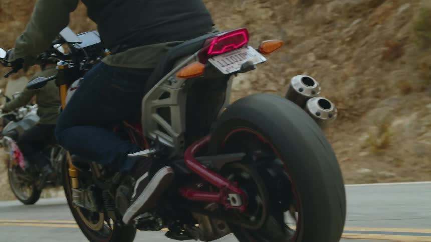 A man drives a motorcycle down a street