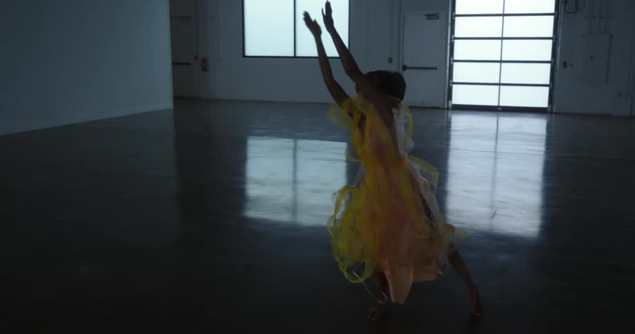 A woman performs a modern dance in an open dance studio