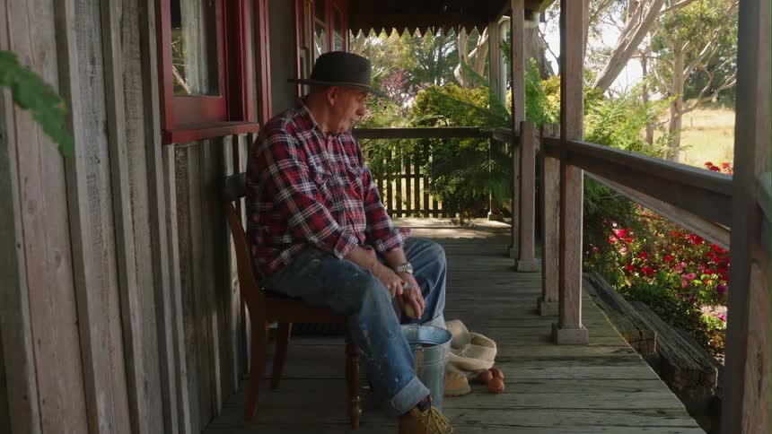 A man is sitting on his porch during spring