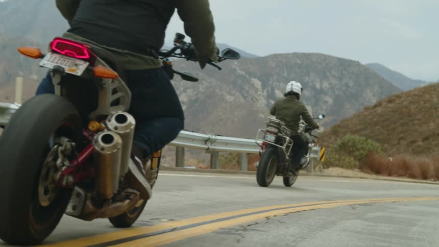 Two men ride motorcycles on the mountain highway