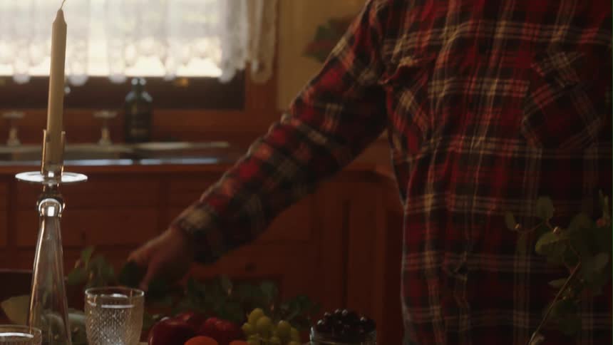 A man decorates his kitchen table for dinner