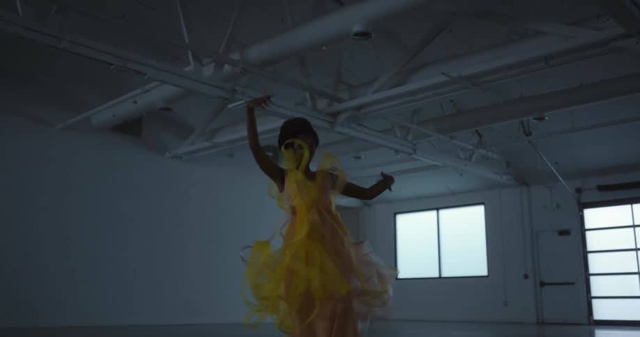 A woman is dancing in a yellow dress
