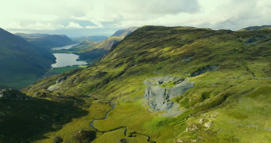 Aerial view of green mountains and valley with lake