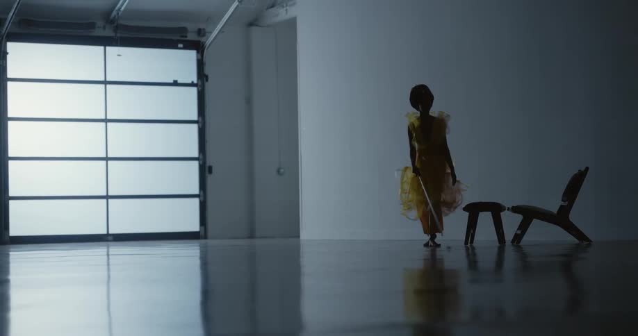 A woman is walking around an empty room