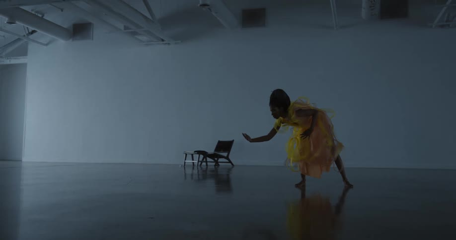 A woman is dancing in a big empty warehouse