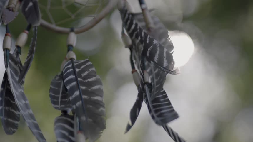 A dreamcatcher swaying in a breeze