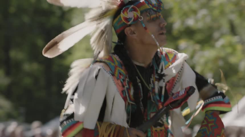 A man in native american indian costume dances