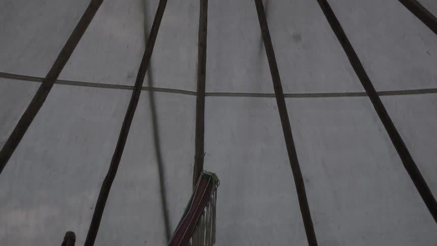 View  of the top of a teepee then moving down from the inside