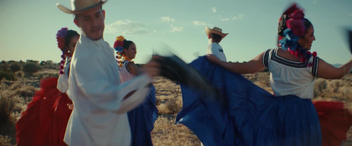 A group of Mexican folk dancers dancing together outside