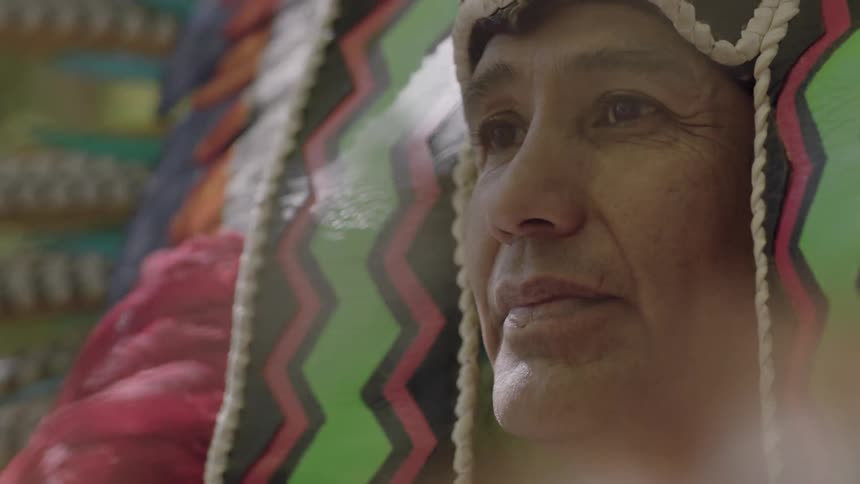 A person wearing a headdress smiles