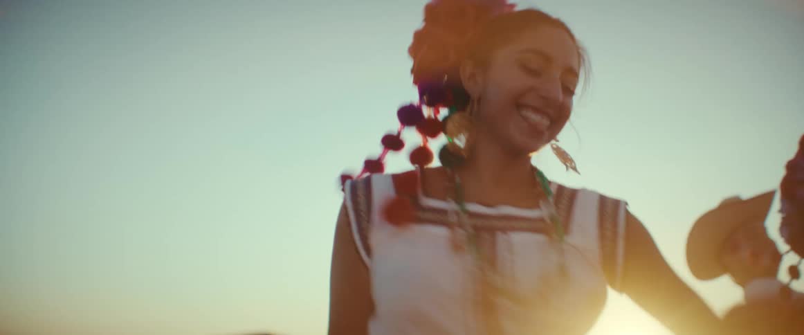 A woman in traditional clothing dances outside