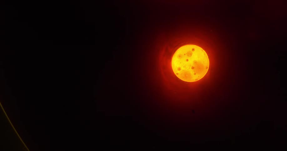 The moon glows orange in the night sky